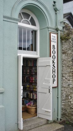 an open door to a book store on the side of a building with bookshelves