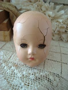 an old doll head is sitting on a doily