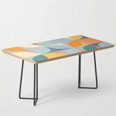 a table with an abstract design on the top and black metal legs, against a white background