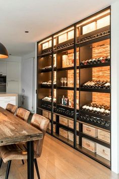 a wooden table sitting in front of a wine rack filled with bottles