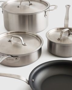 pots and pans with lids on a white surface