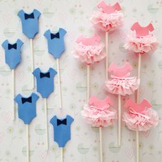 there are some cake pops with pink and blue decorations on them next to each other