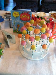 a table topped with lots of cake pops and lorax candies on sticks