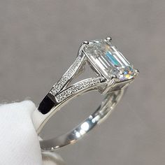 an engagement ring with a large emerald cut diamond