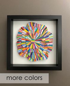 an art piece is displayed in a black frame with the words more colors below it