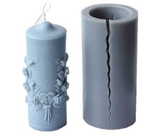 a blue vase sitting next to a gray candle