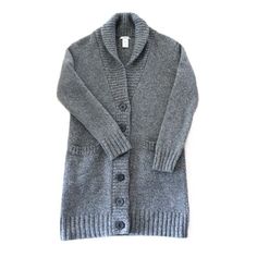 Step into the nostalgia of the 90s with this exquisitely made GAP cardigan, a blend of classic style and cozy comfort.       *   Authentic Vintage Quality: Sourced from the iconic 1990s, this GAP cardigan embodies classic comfort with timeless style.       *   Premium Material: Crafted from 100% lambswool, ensuring a soft, warm, and luxurious feel.       *   Unique Design: Features a sophisticated midi length that reaches mid-thigh, perfect for layering over your favorite outfits.       *   Deta Classic Gray Wool Cardigan, Classic Gray Cardigan For Fall, Cozy Wool Cardigan With Button Closure, Cozy Wool Sweater With Button Closure, Cozy Wool Sweater Coat With Button Closure, Cozy Gray Wool Sweater Coat, Classic Gray Knit Cardigan, Gray Wool Cardigan For Winter, Gray Wool Cardigan For Cold Weather