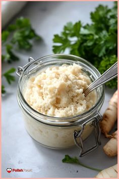 a glass jar filled with mashed potatoes and parsley next to some sliced ginger