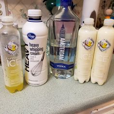 several bottles of hand sanitizers on a kitchen counter with soap, water and toothpaste