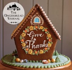 a gingerbread house with the words give thanks written on it