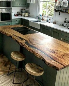 a kitchen with an island made out of wood and two stools in front of it