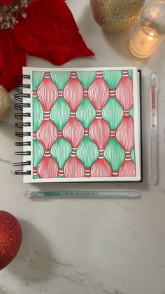 an open notebook on a table next to christmas decorations