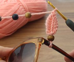 a pair of glasses being worked on with yarn and crocheted eyeglasses