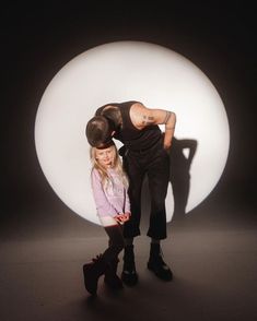 a man and woman standing in front of a large white ball with their arms around each other