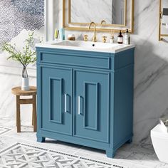 a bathroom with marble walls and flooring, blue vanity cabinet next to the toilet