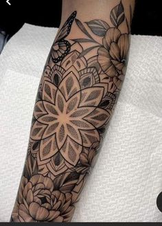 a woman's arm with flowers and butterflies on it