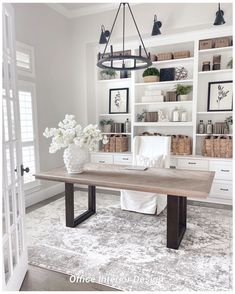 a large wooden table sitting in front of a white book shelf filled with lots of books