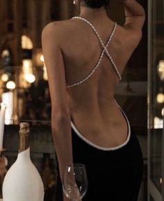 the back of a woman's body in front of wine bottles