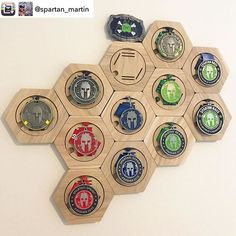 a wooden hexagonal wall hanging with many different badges attached to the back of it