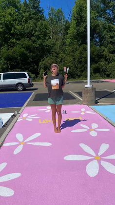 a woman standing on top of a pink flower covered parking lot