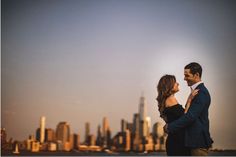 a man and woman standing next to each other in front of a city skyline