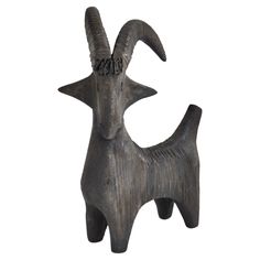 an animal statue made out of wood with horns on it's back and legs