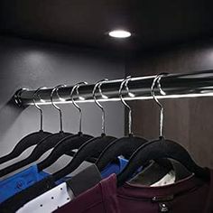 there is a coat rack with clothes hanging on it and other items in the closet