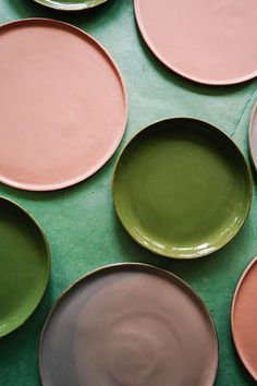 many different colored plates on a green surface