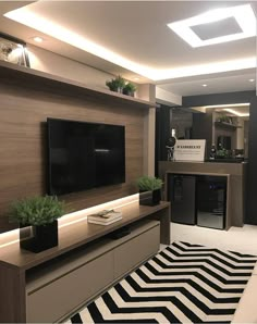 a living room filled with furniture and a flat screen tv on top of a wooden entertainment center