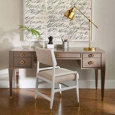 a desk with a chair, lamp and painting on the wall