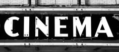 an old movie theater sign with the word cinema painted on it's front door