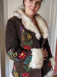 Amazing suède Penny Lane with colourful embroidery. 100% sheepskin. This jacket is made from leftover material in Afghanistan. So it is a sustainable made jacket, based on vintage jackets.  It has not been worn, so in that sense it is new. Will fit size M small L. Size S oversized.  Length: 78 cm Pit to pit: 57 cm Winter Brown Outerwear With Floral Embroidery, Bohemian Hand-stitched Outerwear For Winter, Brown Floral Embroidered Outerwear For Winter, Hand-stitched Bohemian Outerwear For Winter, Long Penny Lane Coat, Pink Penny Lane Coat, Bohemian Hand-stitched Winter Outerwear, Brown Floral Embroidered Winter Outerwear, Vintage Penny Lane Coat