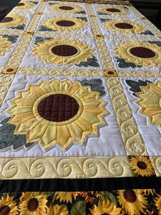 a quilted table runner with sunflowers on it