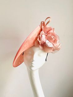 Salmon Pink Mother of the bride hat This amazing hat is made of salmon pink sinamay disc. On the side of it sits matching silk and velvet flower. There is a hidden comb attached to the silk covered headband. The hat will sit steady on your hair attached by the comb. Salmon Pink mother of the bride hat will fit an average head size. It will be an amazing accessory to compliment your outfit and will make your day feel special. Enjoy your special day! Elegant Pink Hat For Kentucky Derby, Pink Fascinator With Handmade Flowers For Evening, Pink Evening Fascinator With Handmade Flowers, Pink Handmade Flowers Fascinator For Evening, Pink Fascinator For Kentucky Derby Evening, Spring Curved Brim Hat For Mother Of The Bride, Elegant Pink Fascinator With Curved Brim, Pink Sinamay Hat For Spring, Elegant Pink Brimmed Hats