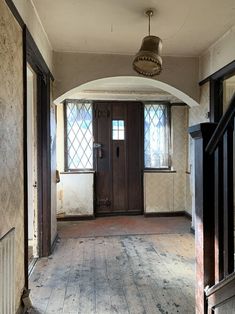 an empty room with wooden floors and a door leading to another room in the background