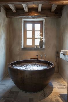 a large bathtub sitting in the middle of a bathroom next to an open window