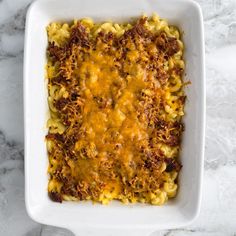 a casserole dish with meat and cheese in it on a marble countertop