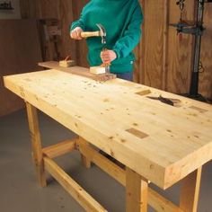 a person using a hammer to cut wood with a table sawtoothing board on it