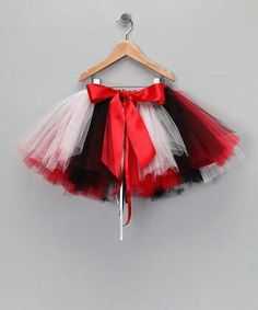 a red, white and black tutu skirt hanging on a hanger