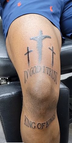 a man with tattoos on his legs and the words in god trust king of kings