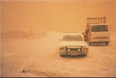 two cars parked in the middle of a desert