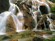 there is a waterfall in the middle of some rocks