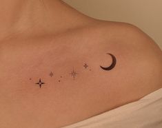 a woman's chest with three stars and a crescent tattoo on her left shoulder