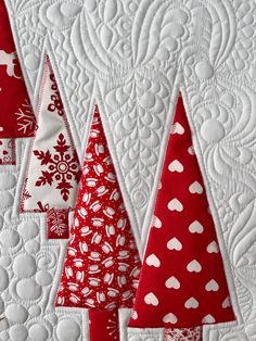 three red and white christmas trees on a quilt