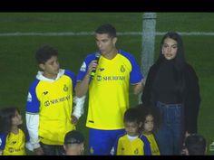 a group of people standing next to each other on a soccer field with a referee in the background