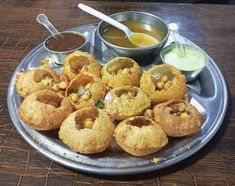 some fried food is on a plate with dipping sauces