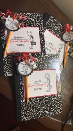 three children's personalized notebooks with writing on them