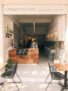 the inside of a coffee shop with tables and chairs in front of an open door