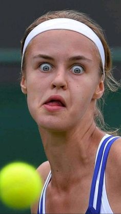 a female tennis player is making a face with her racket and ball in the air