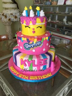 three tiered birthday cake decorated with pink and yellow frosting